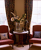 Upholstered armchairs either side of round side table