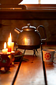 Traditional Swedish kettle with second hand candlesticks in wood hut in Svartadalen, Sweden