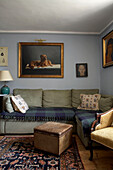 Artwork displayed above corner sofa with patterned rug in Rye living room, Sussex