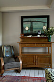 Artwork above wooden sideboard with armchair in Rye, Sussex