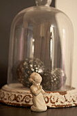 Figurine of child praying and bell jar