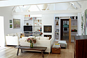 White beamed living room with televisions on shelving unit