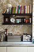 Offene Regale und goldgemusterte Tapete in der Küche eines Londoner Modedesigners