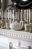 Glassware and pottery teapot on white mantlepiece