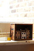 Handbemalte Puppenhäuser mit Spielzeugbooten auf der Fensterbank in einem Haus in Brighton, UK