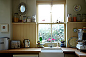 Sash window above sink in Brighton kitchen, Sussex, UK