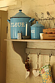 Storage tins and candle on shelf in West Sussex home, England, UK