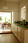 View through sliding door of green tiled kitchen to dining area of Brighton townhouse, Sussex, England, UK