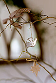 Nahaufnahme einer kleinen Silberdekoration in Form einer Taube, die am Zweig hängt