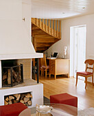 Sitting room with a inbuilt corner fireplace and a wooden staircase in the background