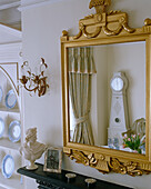 Gustavian clock reflected in mirror in Swedish style dining room