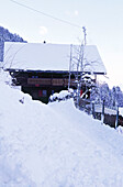 Exterior of snow covered Swiss chalet in mountains