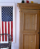 Holzkleiderschrank neben gerahmter amerikanischer Flagge