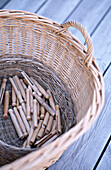 Clothes pegs in wicker basket