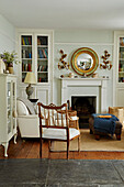 Wooden chair and dresser with vintage mirror above mantlepiece in Port Issac beach house Cornwall