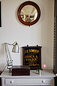 Vintage-Spiegel über Aufbewahrungsboxen mit Schreibtischlampe in Shoreham by Sea, West Sussex, UK