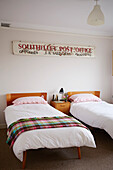 Twin beds below vintage sign in Shoreham by Sea, West Sussex, UK