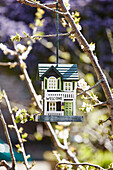 Wooden painted house hanging in garden of Bridport home, Dorset, UK