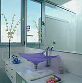 Contemporary white bathroom with large mirror and coloured glass sink
