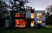 Argentinian cube house covered in brick coloured textured materials with an overhead water tank