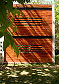 The facade shows a structure made of rusty looking iron with elongated openings Ø°a typical feature of the houses designed by this architect