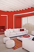 Rotes Wohnzimmer mit poliertem Portlandzementboden und Eukalyptusbalkendecke
