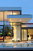 Contemporary glass cube house with swimming-pool merging exterior to bedrooms and living-room