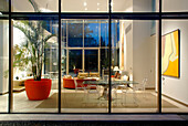 Blick durch eine gläserne Kubus-Fassade im minimalistischen Stil in den Innenraum