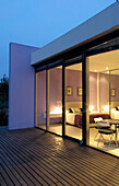 View through windows of cube house with decking to bedroom