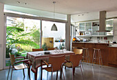 Kitchen table and chairs with bar area for three people and sliding doors to garden