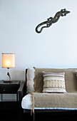 Beige throw and cushion on sofa with side table and lit lamp