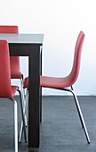 Rosa Stühle am Esstisch auf geglättetem Betonboden