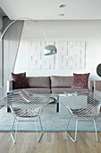 Wohnzimmer mit Metallstühlen im Design des 20. Jahrhunderts und einer Klassiker-Lampe