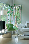Lindgrüner Sessel mit Bambus am Eckfenster