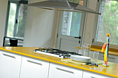 Extractor over hob fitted in yellow Formica kitchen worktop