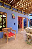 Eichentisch und Sitzbank mit Kaktus am Eingang zur blau gestrichenen Veranda