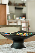 Black bowl on lace table runner filled with confectionary