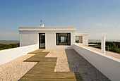 Whitewashed exterior with gravelled roof terrace and wooden walkway