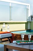 Two wine glasses on serving tray on wooden table in roof garden, Buenos Aires, Argentina