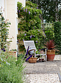 Liegestuhl aus Holz auf einer Gartenterrasse