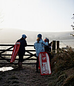 Children with sleds opening gate