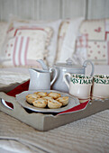 Teapot and milkjug with cups and mince pies on kitchen tray
