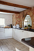 Küche mit weißen Bodenfliesen und Schränken mit Granitarbeitsplatte und Sichtziegeln
