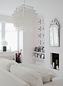 All white living room with decorative light shade artwork and silver embossed mirror