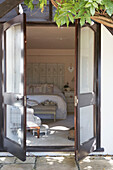 View through double doors into bedroom with folding screen headboard