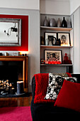 Red accent colours and shelving in living room of Grade II listed Georgian townhouse in London