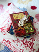 Vintage children's books and brooch on patterned tabletop