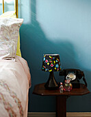 Black telephone and lamp on wooden bedside table