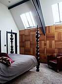 Sculptural bedposts in panelled room with skylights in Richmond school church conversion