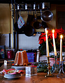 Kerzen und Dessert auf dem Tisch in der Küche eines walisischen Bauernhauses aus dem 16. Jh.